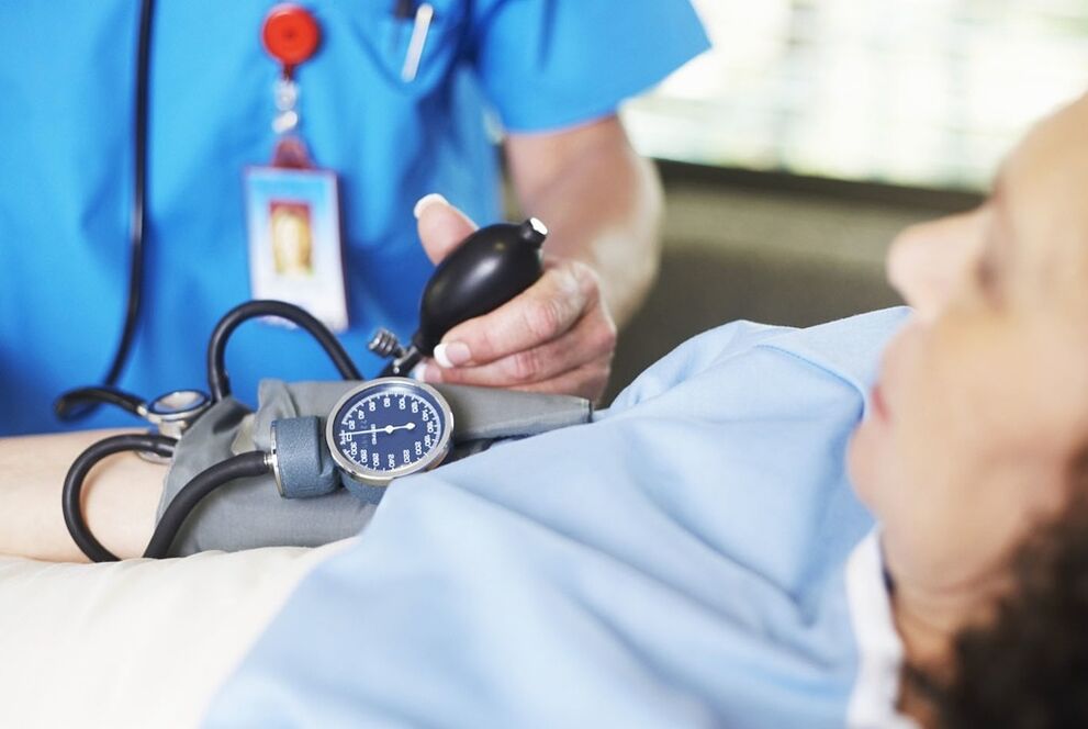 Zdravnik meri tlak bolnika s hipertenzijo